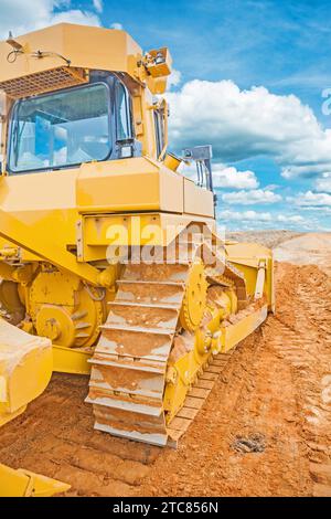 Bulldozer standing on sand in construction site rear view Stock Photo