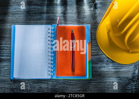 Checked notebook pen safety cap on wooden board Stock Photo