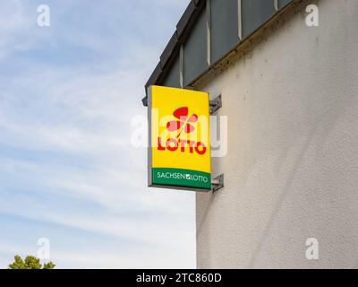 Lotto logo sign of the Sachsenlotto company. The state lottery offers gambling in Saxony. Illuminated advertisement on a building exterior of a kiosk. Stock Photo