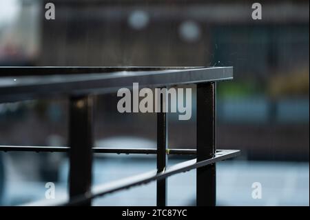 Aluminium bars of a terrace with rain splashing, Jette, Brussels, Belgium Stock Photo