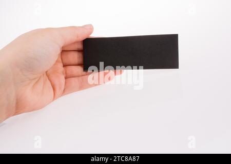Hand holding a piece of black paper on a white background Stock Photo