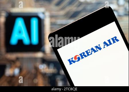 In this photo illustration, the largest airline and flag carrier of South Korea, Korean Air, logo seen displayed on a smartphone with an Artificial intelligence (AI) chip and symbol in the background. Stock Photo