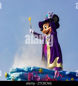 A picture of a happy Mickey Mouse riding on top of a parade Stock Photo