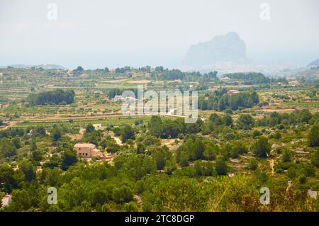 Landscape view of mediterranean countryside with maquis shrubland and Peñón de Ifach limestone outcrop in the distance (Marina Alta, Alicante, Spain) Stock Photo