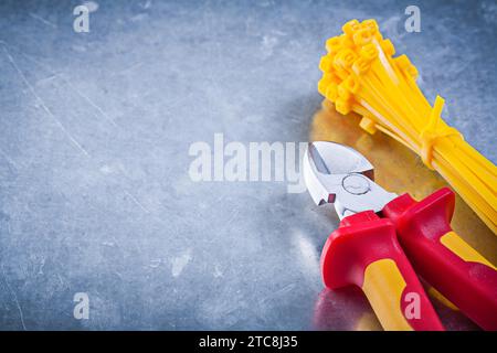 Nippers plastic self-locking cable ties on metallic background construction concept Stock Photo