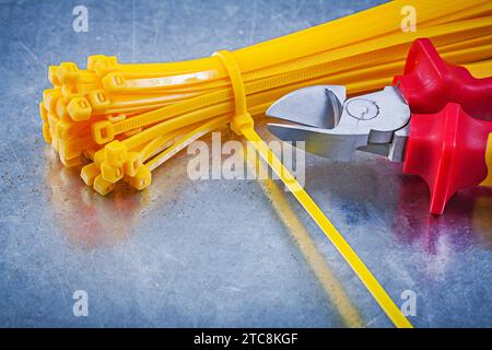 Cutting pliers cable ties on metallic background construction concept Stock Photo