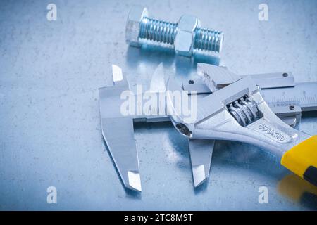 Slide caliper adjustable spanner screw bolt and nut on scratched metallic background construction concept Stock Photo