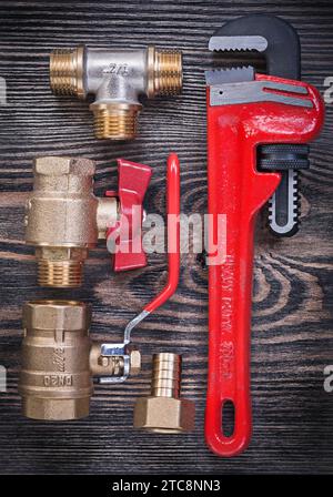 Composition of pipe wrench brass fittings water valve on wood board plumbing concept Stock Photo