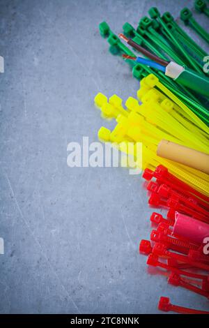 Composition of plastic cable ties on scratched metallic background Stock Photo