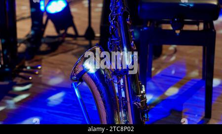 Saxophone on the stage of a town hall in blue light. Stock Photo