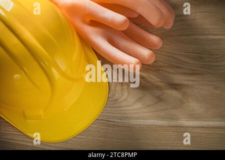 Insulating gloves safety cap on wooden board Stock Photo