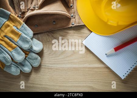 Leather tool belt safety gloves hard hat notebook pencil Stock Photo
