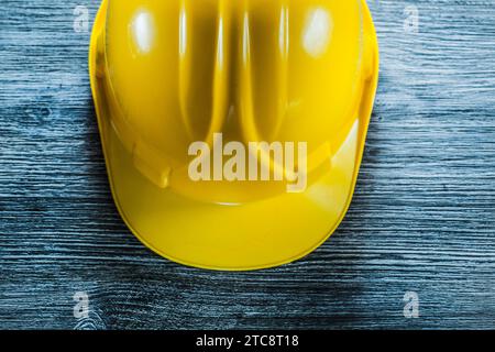 Yellow safety cap on wooden board Stock Photo