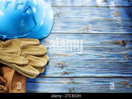 Leather safety gloves cap construction belt on vintage wooden board Stock Photo