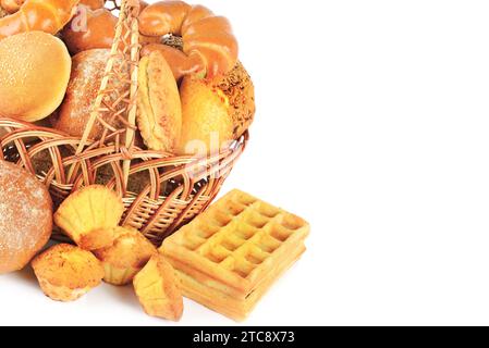 Sweet pastries, bread and flour products in a wicker basket isolated on white background. Free space for text. Stock Photo