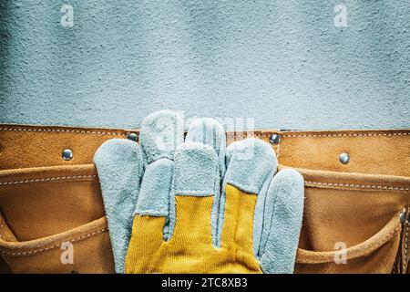 Leather tool belt safety gloves on concrete background Stock Photo