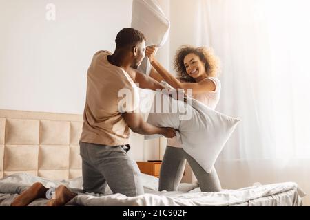 Carefree Young Black Spouses Fighting With Pillows Having Fun Indoor Stock Photo