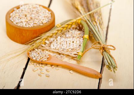 Organic barley grains over rustic wood table macro closeup Stock Photo