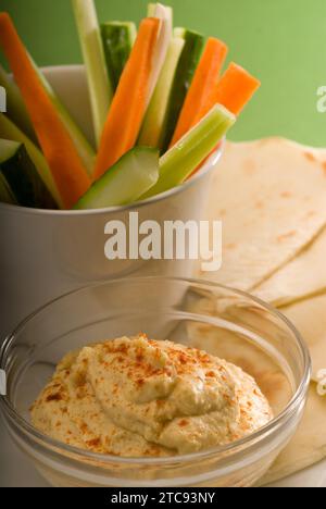 Middle eastern hummus dip on a glass bowl with homemade pita bread and raw vegetable Stock Photo