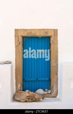 Traditional blue shutters and whitewashed walls on the side of an old greek building. Stock Photo