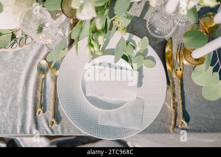 Paper sheet card mockup on minimal table place setting top view on tablecloth. Space for text. Wedding table with invitation. Stock Photo