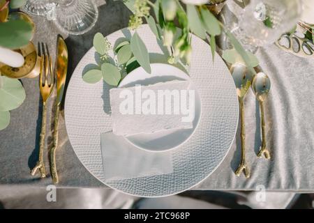 Blank paper sheet card mockup on minimal table place setting top view on tablecloth. Space for text. Wedding invitation, menu. Stock Photo