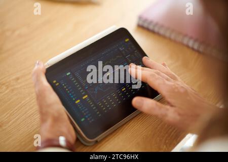 Closeup image of businesswoman analyzing trading data on tablet screen Stock Photo