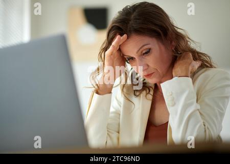 Sad stressed overworked female entrepreneur suffering from migraine headache Stock Photo