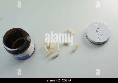 Dublin, Ireland - December 13th 2023: A photo of medical probiotic tablets and its container and lid on a white background. Stock Photo