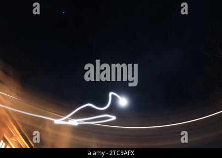 Abstract colorful irregular lines light painting in sky background with stars Stock Photo