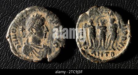 Ancient Roman coin of Emperor Honorius, old damaged metal money isolated on black background. Theme of vintage copper or bronze texture, Rome, Empire, Stock Photo