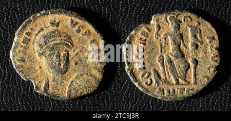 Ancient Roman coin of Emperor Honorius, old worn metal money isolated on black background. Theme of vintage copper texture, Rome, Empire, antique and Stock Photo