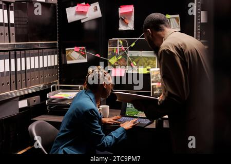 Officers Checking Scene Private detectives checking crime scene photos on map, working to find ...