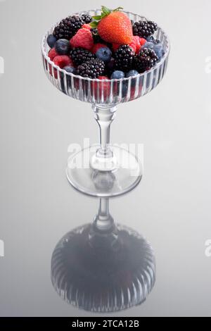 Still alive of mixed Summer fruit served in an elegant stemware glass on a plain background Stock Photo