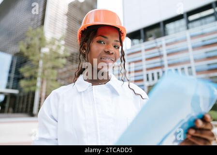 Smiling African American female inspector checking construction documents Stock Photo