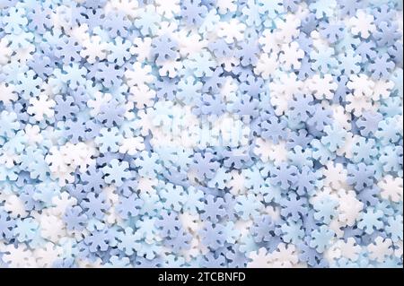 Snowflake shaped sugar sprinkles. Background of blue and white confetti candy, confectionery made of sugar and rice consisting of flat candy sprinkles. Stock Photo