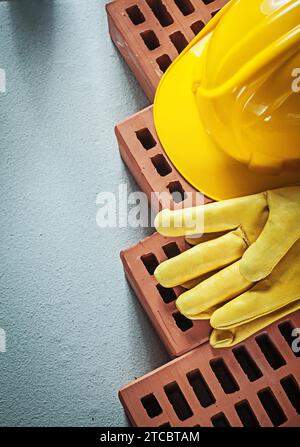 Assortment of building blocks Protective cap Safety gloves on concrete Background construction concept Stock Photo