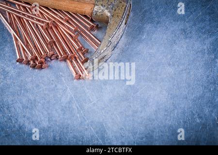Brass construction nails vintage claw hammer on metallic background Stock Photo