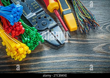 Electrical tester Cable ties Bolt cutters Insulation screwdriver on wooden board Stock Photo