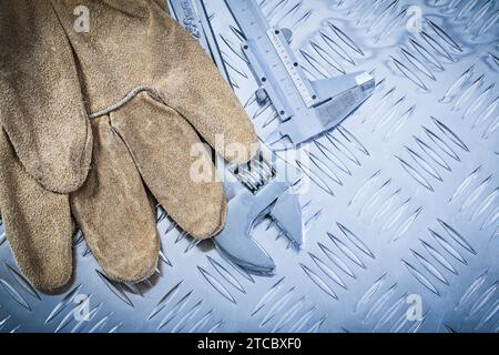Leather safety gloves Trammel Caliper adjustable spanner on corrugated metal construction concept Stock Photo