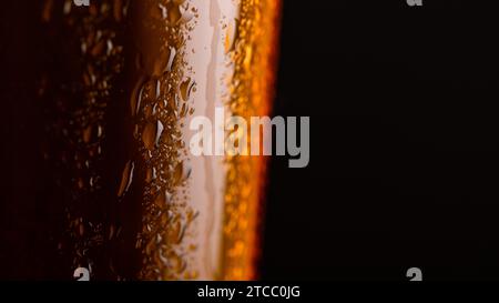 Glass of beer with foam on black background closeup. copy space on right Stock Photo