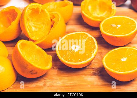 Orange background. Closeup of half cut and squeezed fruits in pattern next to each other. On wooden background Stock Photo