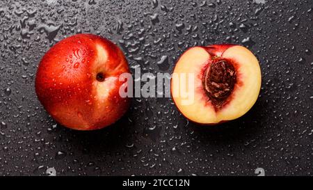 Nectarine fruit isolated on wet black background. Health concept Stock Photo