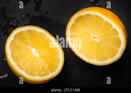 Juicy yellow lemon sliced in half on a black background isolated Stock Photo