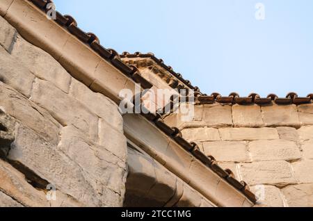 Fragment of the wall and roof of an old house on a background of blue sky Stock Photo