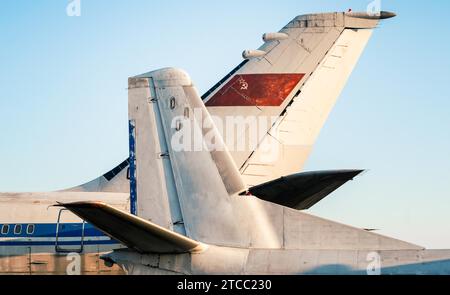 Tail and wings of large old airliners with the symbol of the Soviet Union isolated on a blue sky background Stock Photo