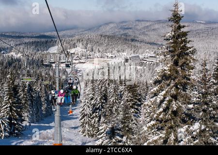 Kopaonik, Serbia, January 22, 2016: Ski resort Kopaonik, Serbia, ski slope, people on the ski lift, mountains, houses and buildings panorama Stock Photo