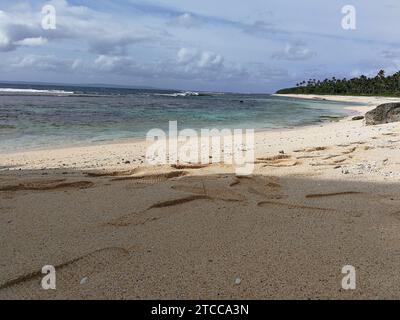 A picture of pristine sandy beach with calm and inviting blue waters, ready for swimming and recreational activities Stock Photo