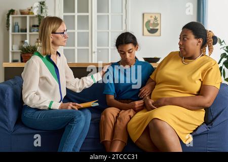 Psychologist having conversation with family, she discussing problems of teenage daughter with her mom Stock Photo