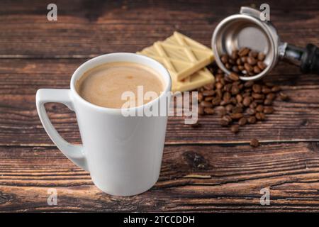 White chocolate coffee in white porcelain cup on wooden table Stock Photo